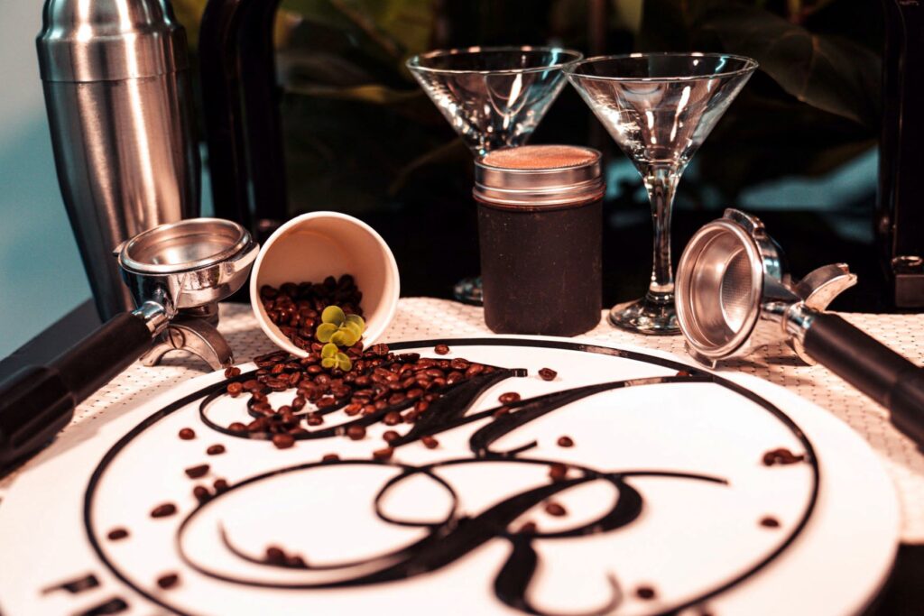 Espresso-Martini-Gläser neben einem Teller mit Maitre-Royal-Monogramm aus Kaffee