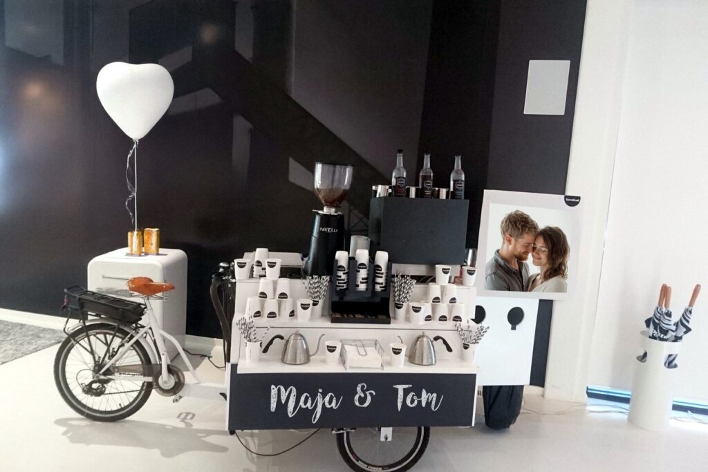 Weißes Kaffeerad von Maitre Royal bei einer Hochzeit, dekoriert mit Herzballon und den Namen des Brautpaars