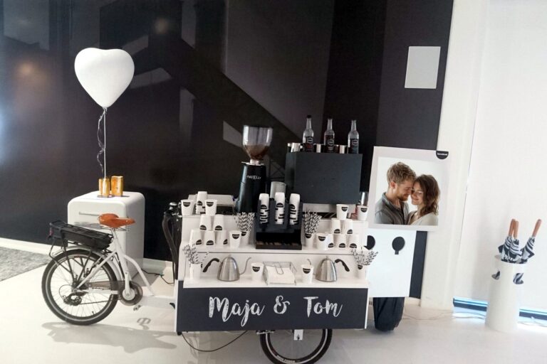 Weißes Kaffeerad von Maitre Royal bei einer Hochzeit, dekoriert mit Herzballon und den Namen des Brautpaars