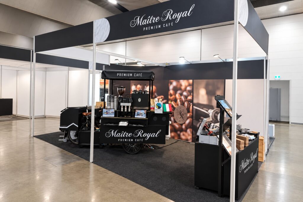 Schwarzes Kaffeerad von Maitre Royal auf einem Messestand in einer Messehalle