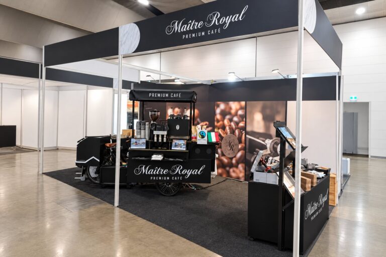 Schwarzes Kaffeerad von Maitre Royal auf einem Messestand in einer Messehalle